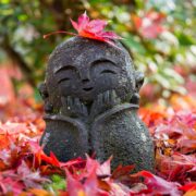 kleine Mönchstatue im Herbstlaub in Japan